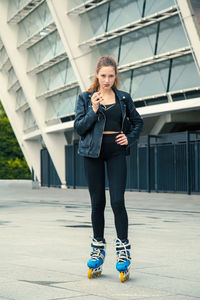 Full length portrait of young woman standing outdoors