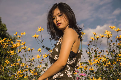 Portrait of woman by yellow blooming flowers