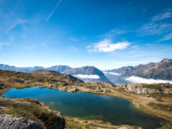 Scenic view of lake and mountains against blue sky