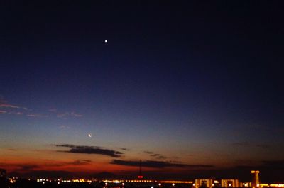 Low angle view of illuminated city against sky at night