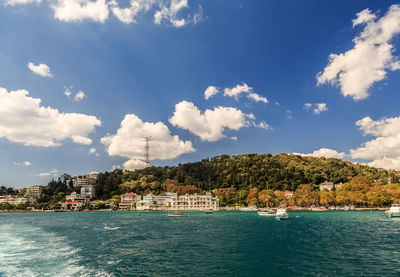 Scenic view of sea by buildings against sky