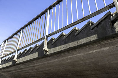 Low angle view of bridge against buildings against clear sky