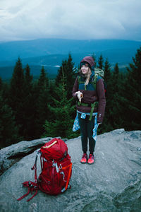 Portrait of woman standing on rock against mountains