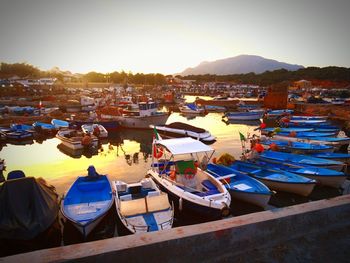 Boats in calm sea at sunset