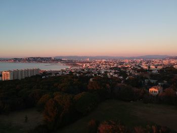 High angle view of townscape by sea against clear sky