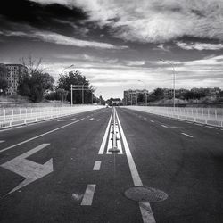 Diminishing view of road against cloudy sky