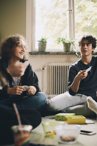 Male friends talking while playing board games at bedroom