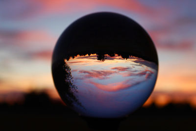 Close-up of crystal ball against sunset