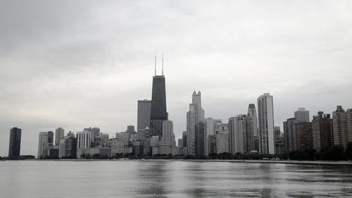 Willis tower in city by lake michigan against sky