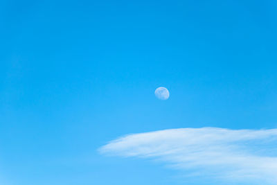 Low angle view of moon against blue sky