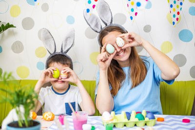 Portrait of siblings playing with daughter at home