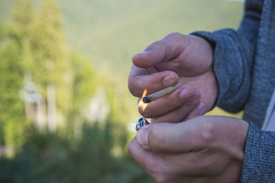 Close-up of hand holding cigarette