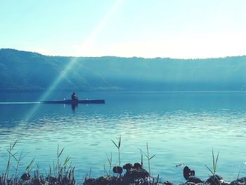 Rear view of woman in lake against clear sky