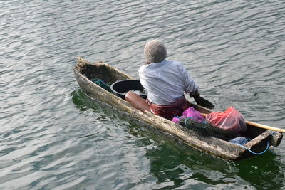 Fisherman sitting on fishing boat in lake