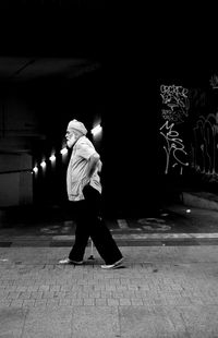 Rear view of person walking on footpath at night