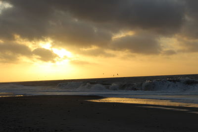 Scenic view of beach against sky during sunset