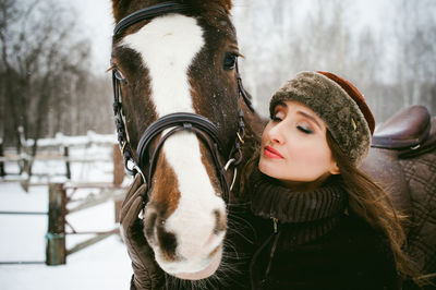 Close-up of woman with horse in winter