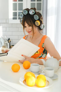 Portrait of smiling young woman using digital tablet on table