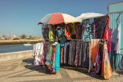 Multi colored umbrellas hanging on clothesline against sky