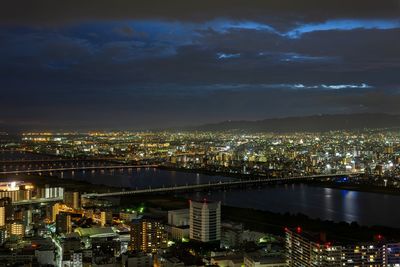 High angle view of illuminated buildings against sky at night