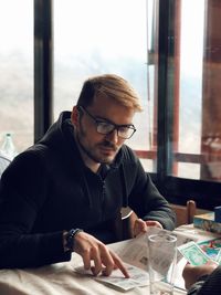 Young man looking at menu in restaurant