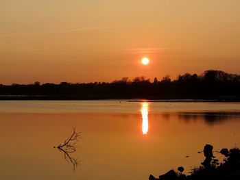 Scenic view of lake against orange sky