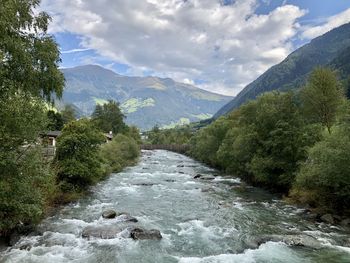 Scenic view of river amidst mountains against sky