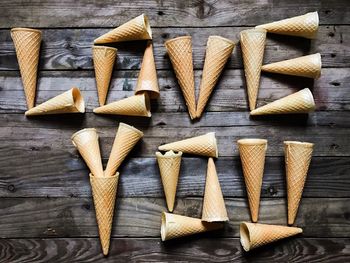 Directly above shot of love you text made from ice cream cones on wooden table