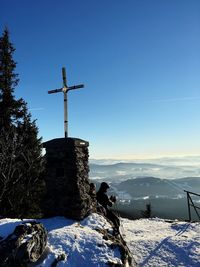 Windmill on mountain against clear blue sky