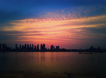 Scenic view of silhouette buildings against sky during sunset