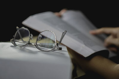 Cropped hand of woman writing in book