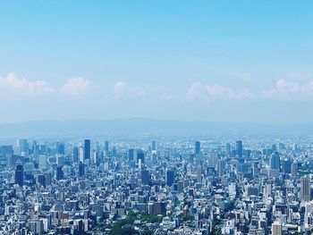 Aerial view of buildings in city against sky