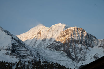 Scenic view of snowcapped mountains against clear sky