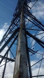 Low angle view of electricity pylon against blue sky