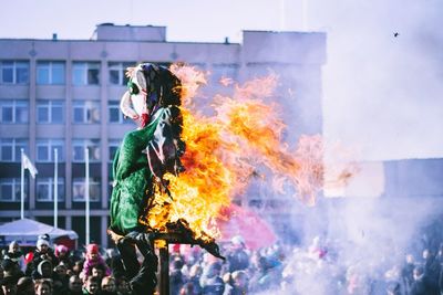 People burning statue in city