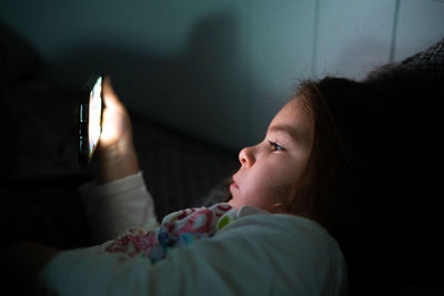 Side view of girl using smart phone at home