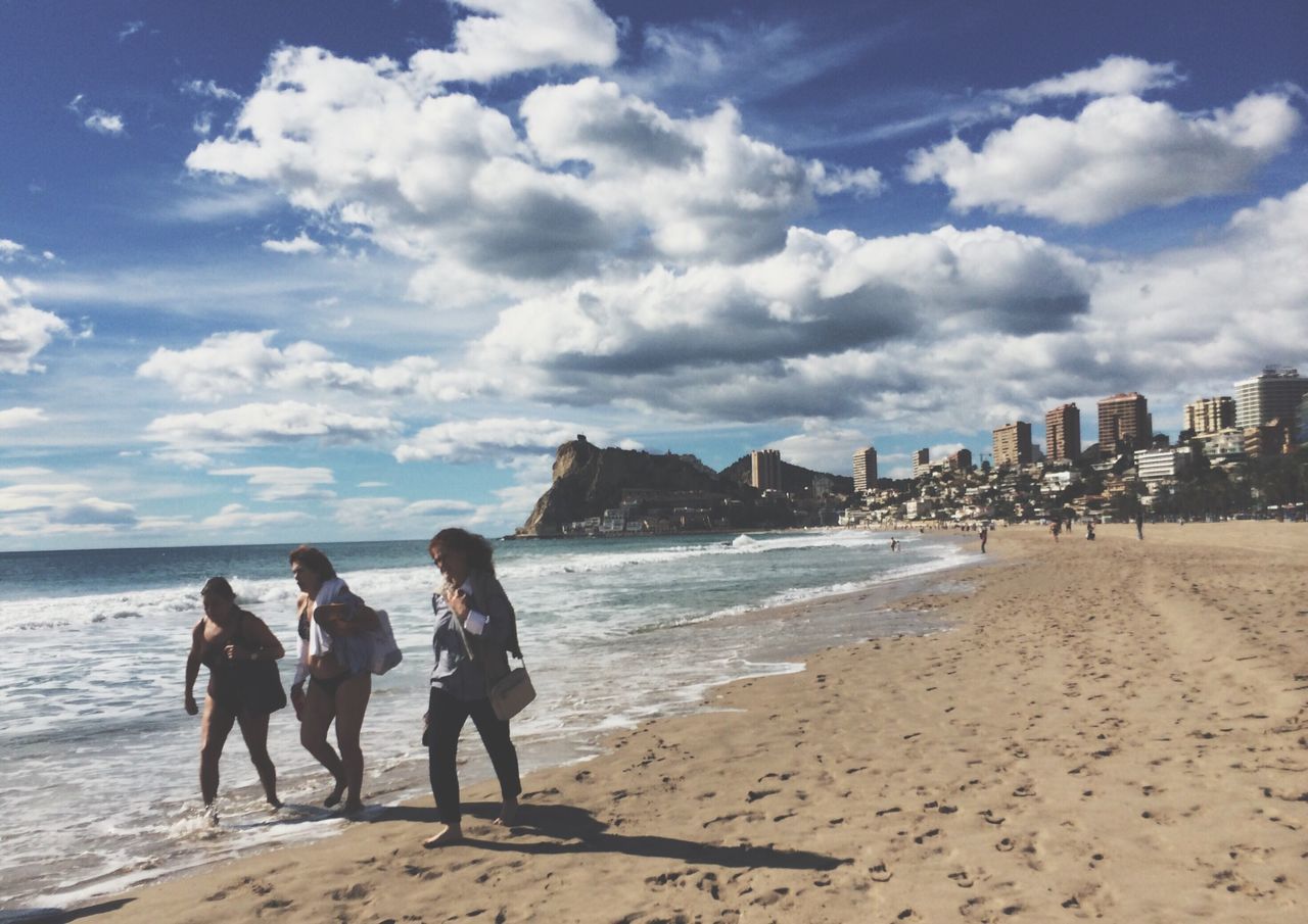 sea, beach, water, shore, sky, men, sand, lifestyles, leisure activity, large group of people, person, vacations, horizon over water, tourist, cloud - sky, mixed age range, coastline, wave, weekend activities