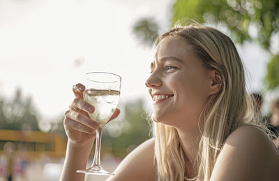 Portrait of a smiling young woman drinking glass