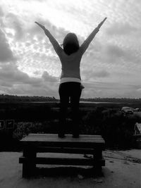 Full length of woman standing against cloudy sky