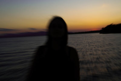 Silhouette woman at beach during sunset