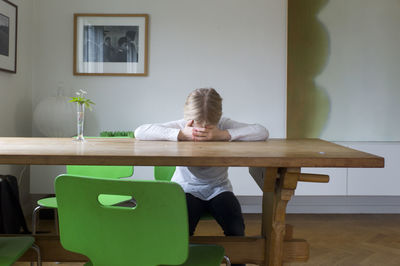 Sad girl sitting at table