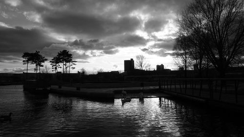 Bridge over river against cloudy sky