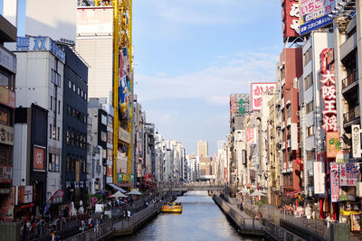 Canal amidst buildings against sky in city