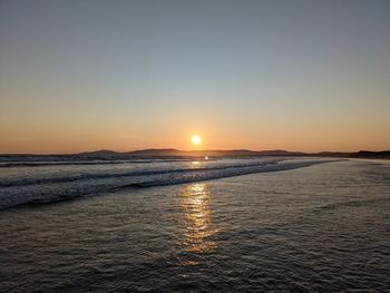 Scenic view of sea against clear sky during sunset