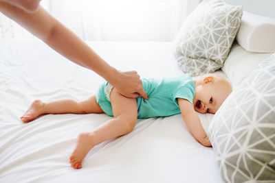 Low section of woman lying on bed at home