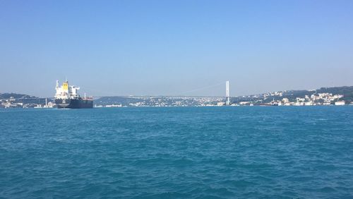 City at waterfront against blue sky