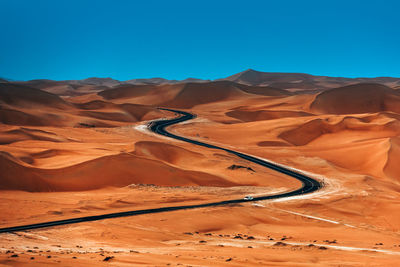 Scenic view of desert against clear blue sky