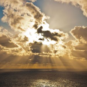 Scenic view of sea against cloudy sky at sunset