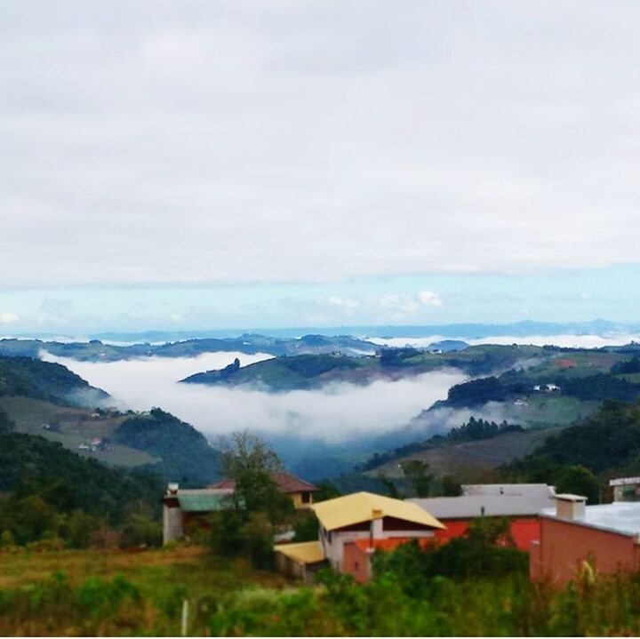 HOUSES BY MOUNTAINS AGAINST SKY