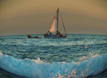 Ship sailing in sea against sky during sunset